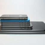 Stacked modern smartphones and tablets showcasing sleek design. Perfect tech background.